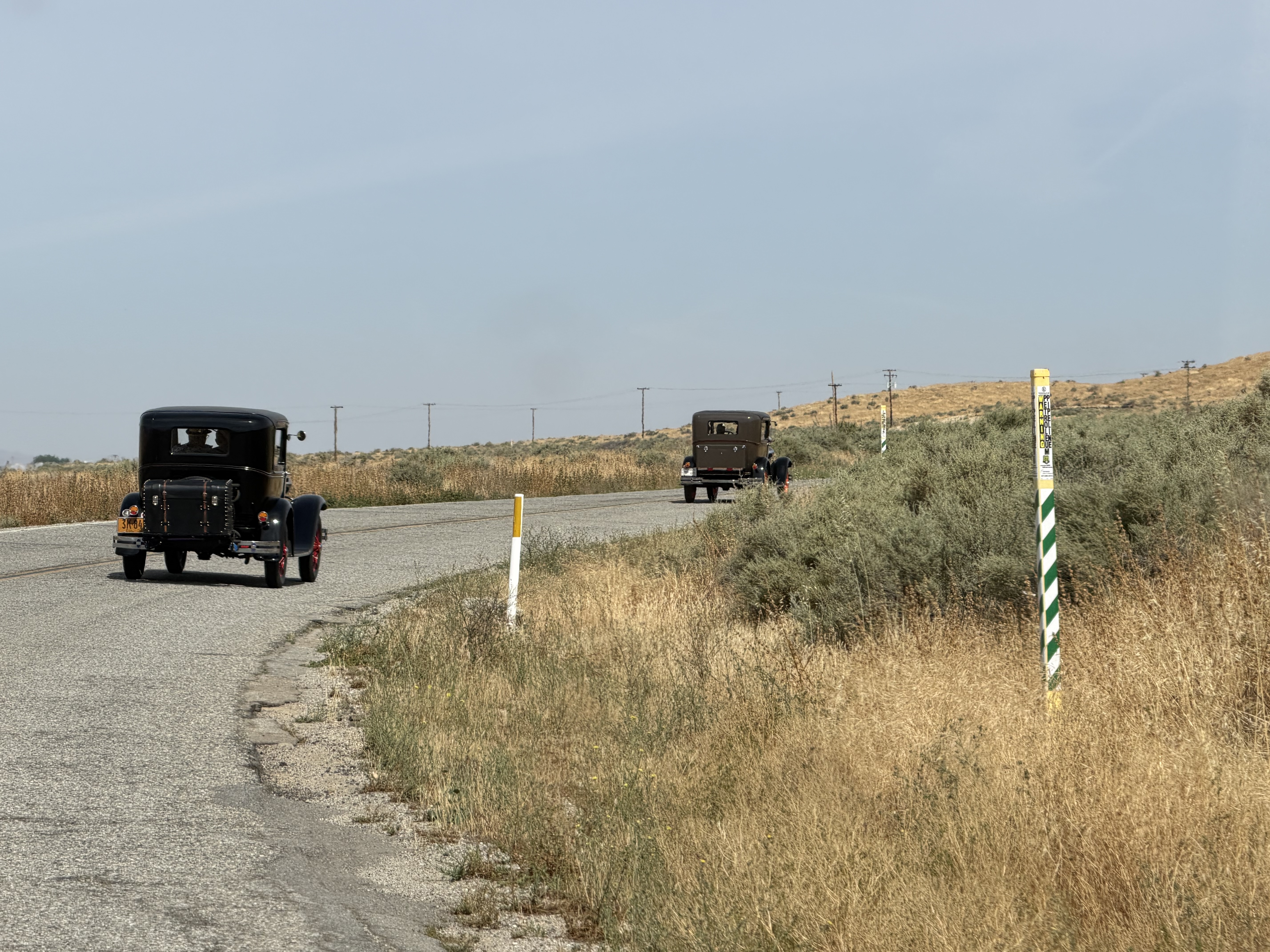 Model A Fords traveling on a country road