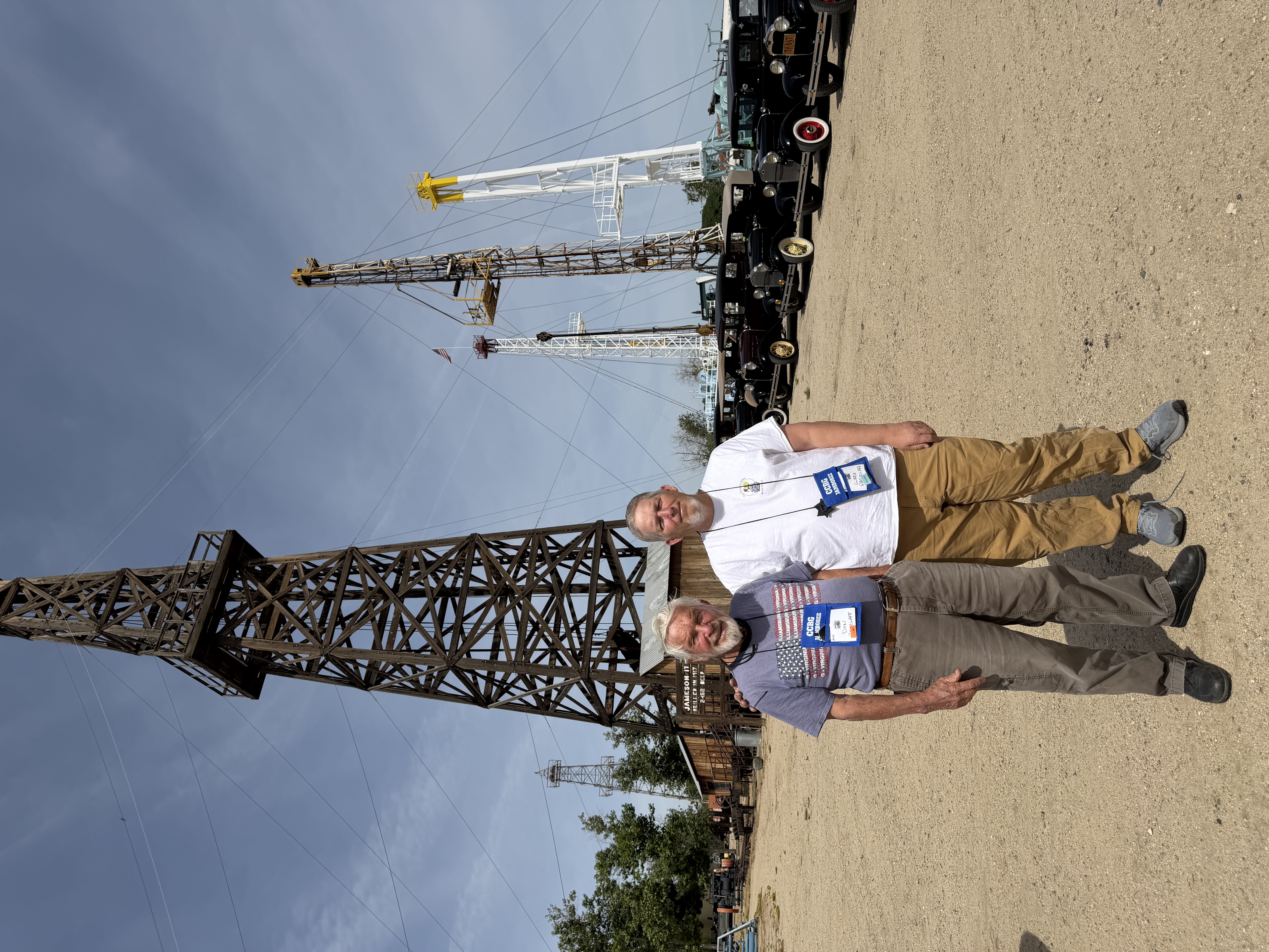 Two club members beside historic oil equipment